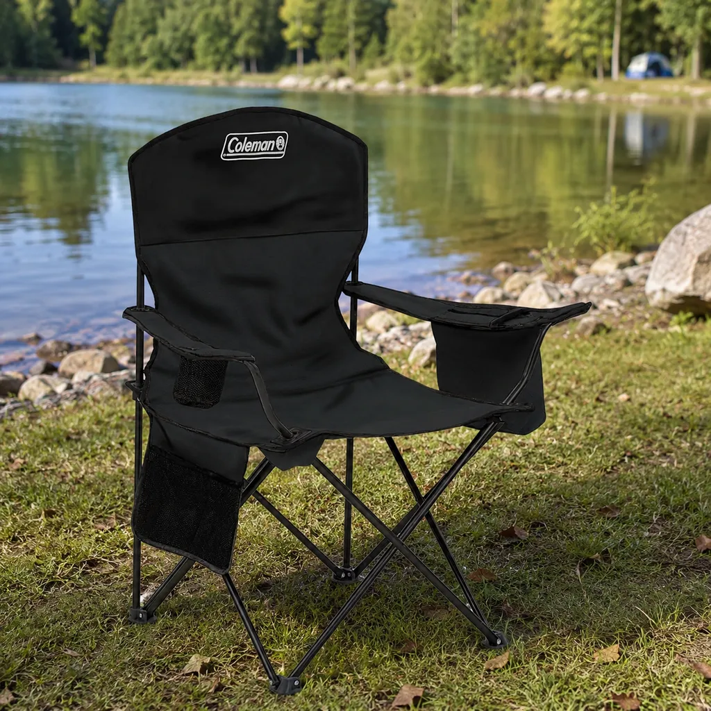 Coleman portable quad camping chair with cooler pouch on grass by a lake