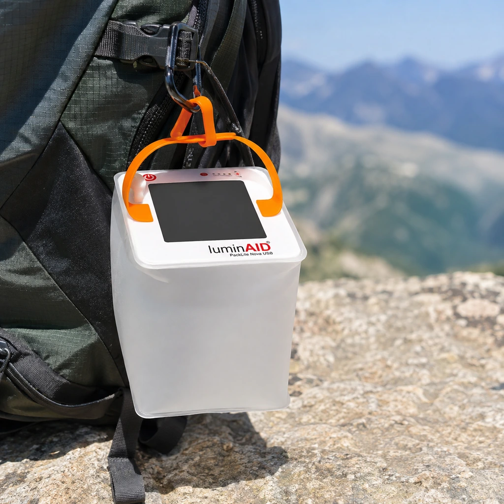 LuminAID Nova inflatable solar lantern hanging from a backpack in sunlight