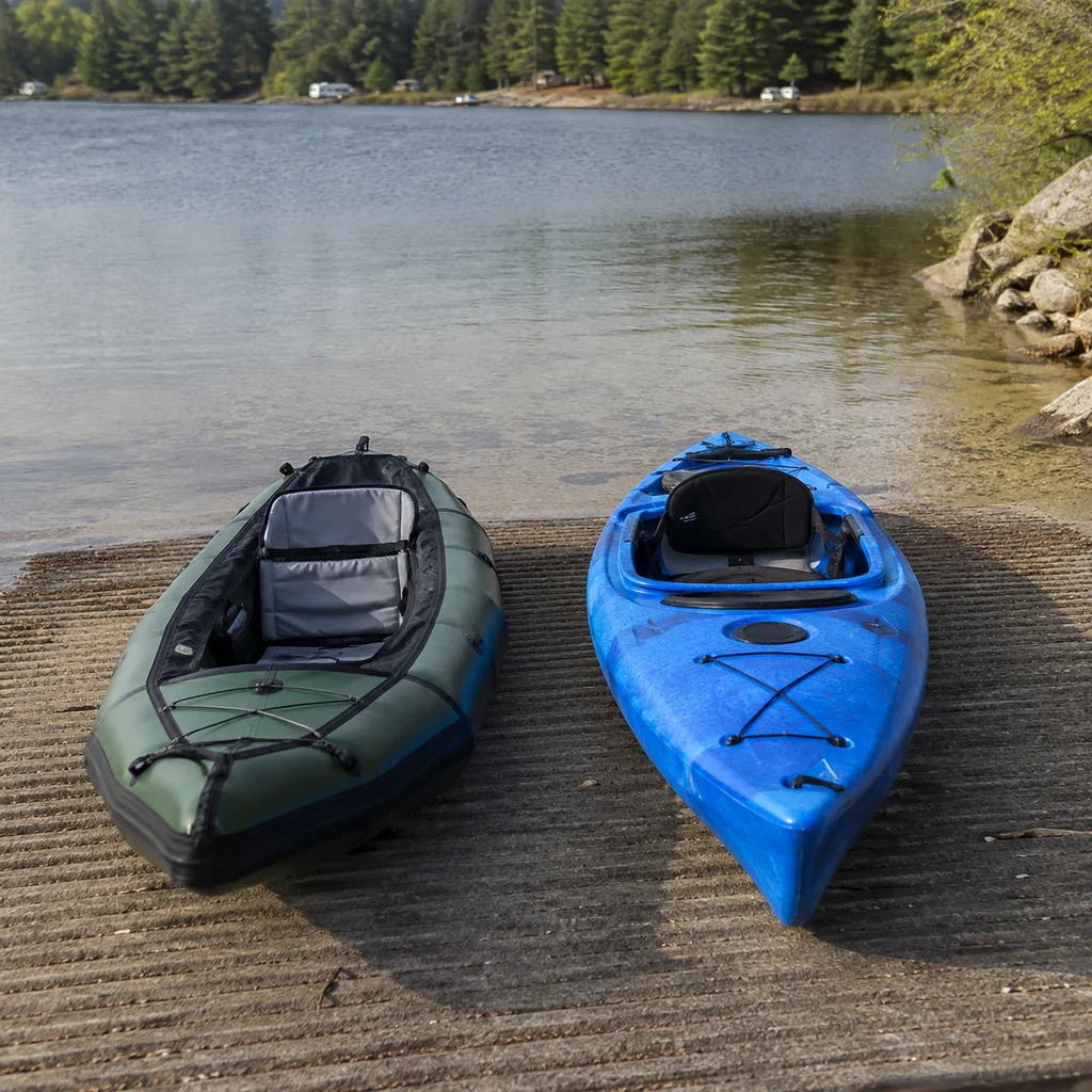Inflatable kayak beside a rigid hard shell kayak on a launch ramp
