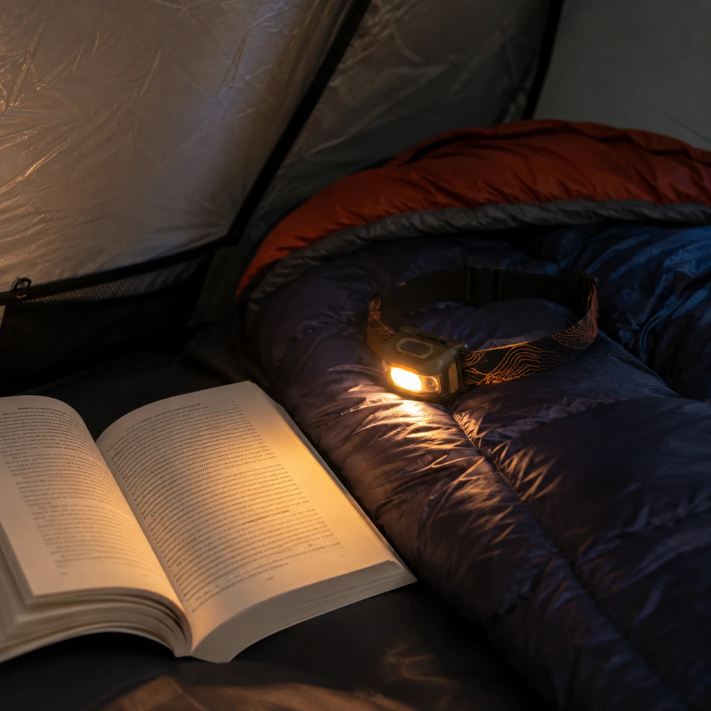How many lumens for a camping headlamp: a low warm setting lighting a book in a tent
