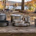 The best camping cookware sets laid out on a picnic table at an autumn campsite