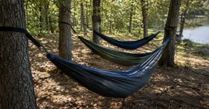 The best camping hammocks hung in a row at a wooded campsite