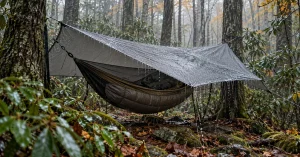 Hammock under a taut grey hex tarp in steady rain in the Smokies