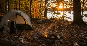 Fall camping essentials at a golden hour campsite with a tent and campfire