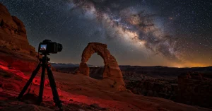 Camera on a tripod under the Milky Way at Delicate Arch, Utah